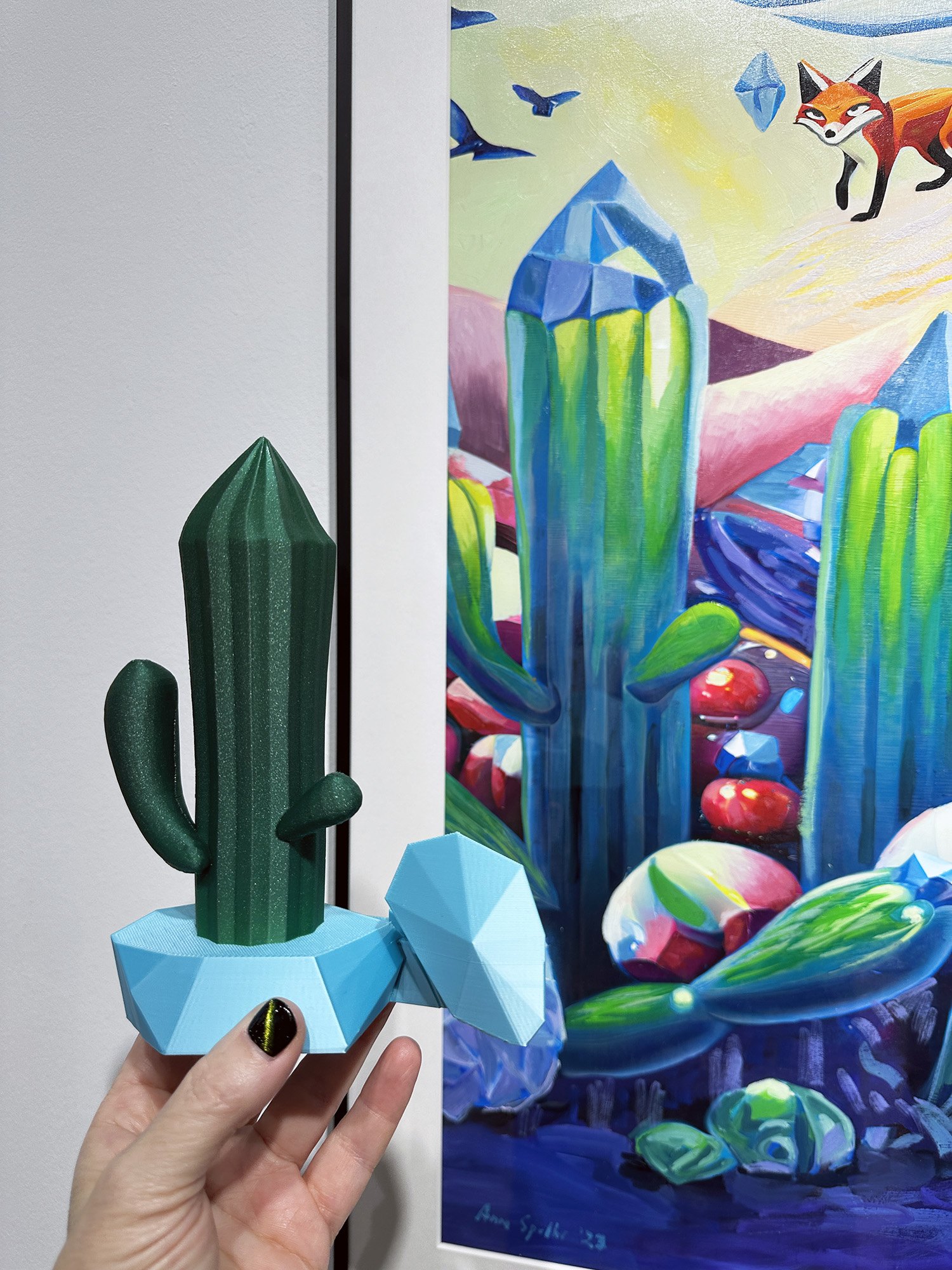 Desert Diamond held next to Deserted Dreams, the painting it was extracted from